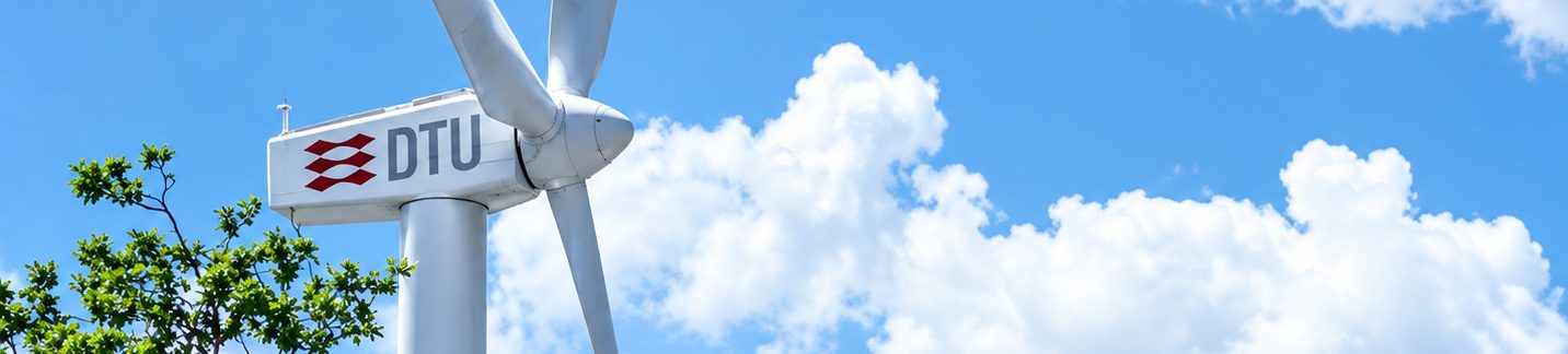 A DTU-branded wind turbine against a blue sky